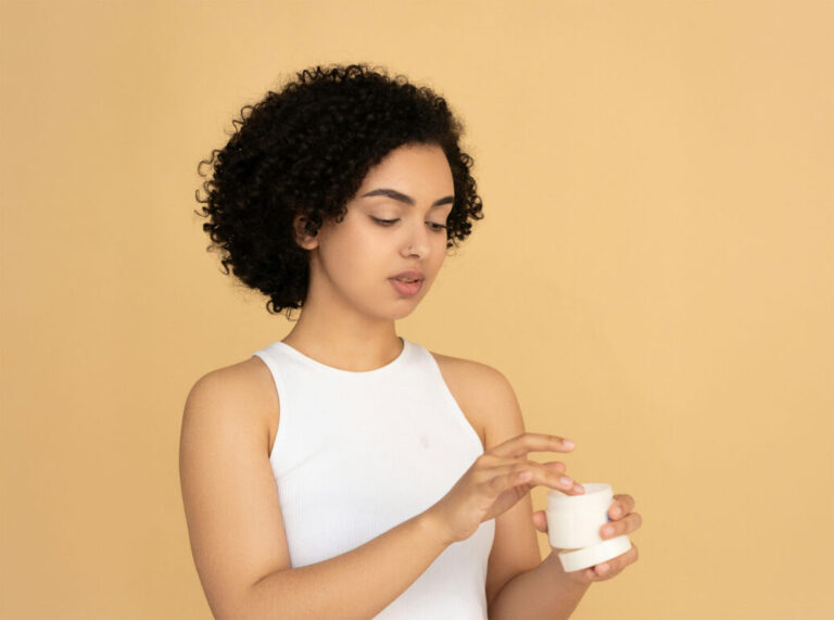 Woman in a White Tank Top Holding A Beauty Cream