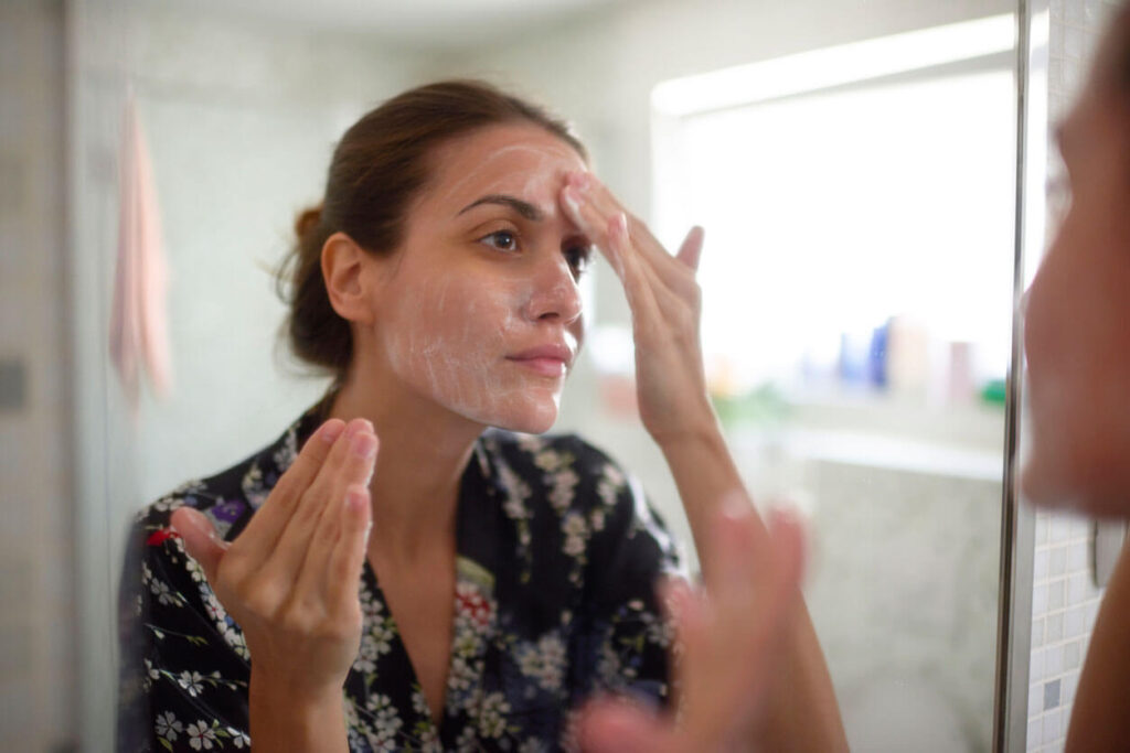 Beauty Blog Woman in the bathroom applying gentle facial moisturizer with spf