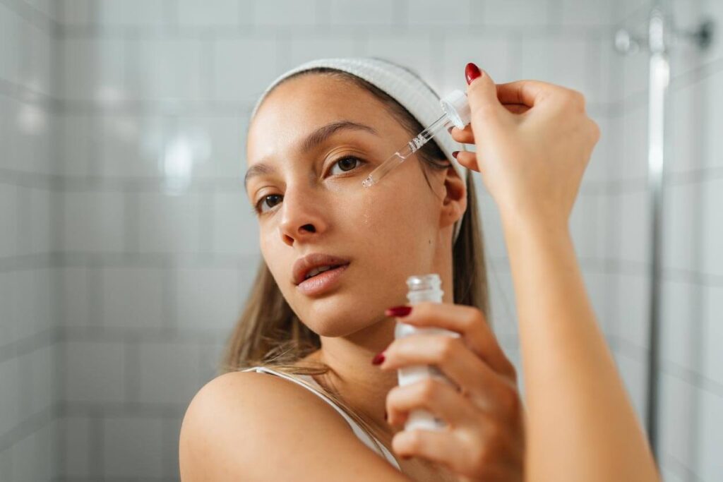 Beauty Blog Young Woman Applying hyaluronic acid serum vs moisturizer