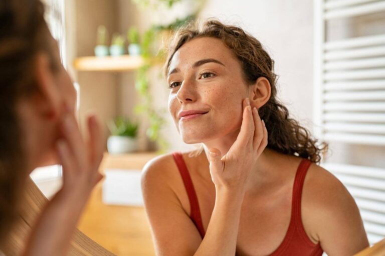 Young beauty woman checking her skin at mirror in the morning stock photo