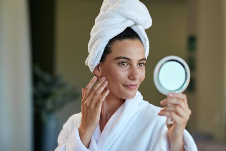 Beautiful mid adult woman after shower looking at mirror stock photo