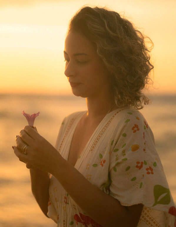 Beauty Blog Woman Enjoying Serene Beach Sunset with Flower