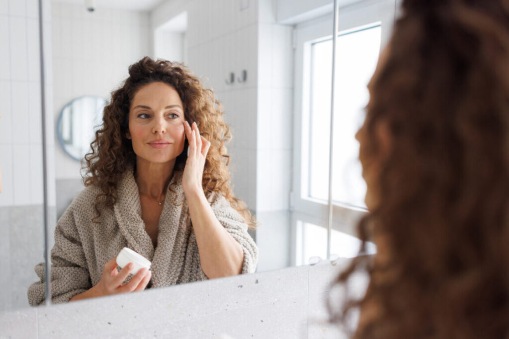 Beauty Blog Mid adult woman applying skincare cream in the bathroom