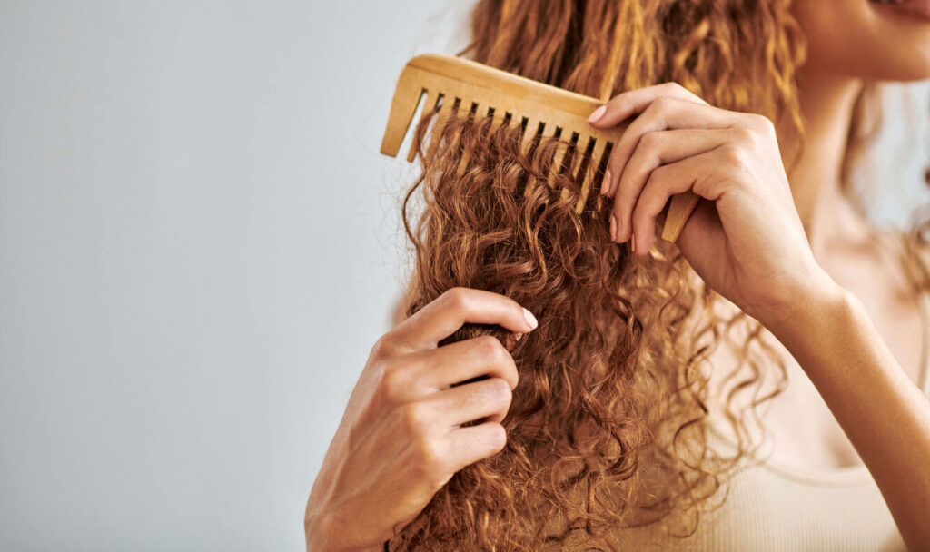 Beauty Blog female hands comb natural hair in morning routine