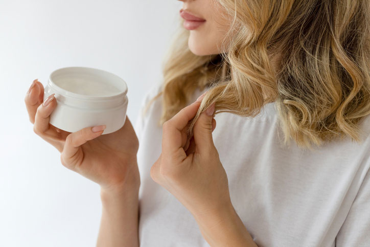 Female applying hair mask to dead hair ends stock photo