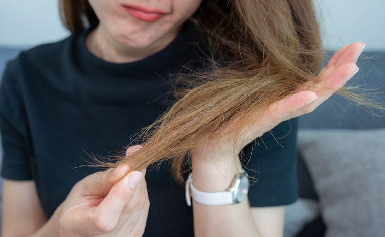 Beauty Blog woman holding her damaged split ended hair